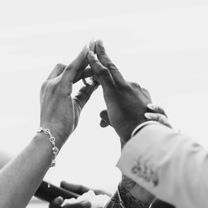 Two pairs of hands raised and joined above the dance floor.