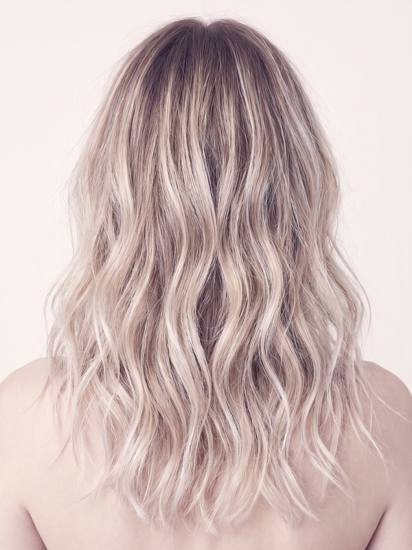 Back view of long lived-in balayage waves, a soft blonde melt through the ends.